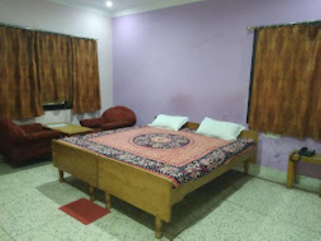 - une chambre avec un lit, une chaise et des rideaux dans l'établissement PARK VIEW PALACE,Bhubaneswar, à Bhubaneswar