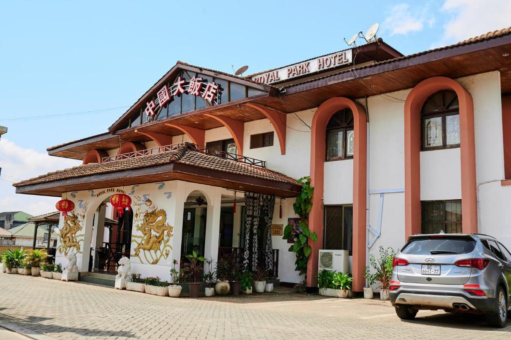 un coche aparcado frente a un edificio en ROYAL PARK HOTEL AND CHINESE RESTAURANT, en Kumasi