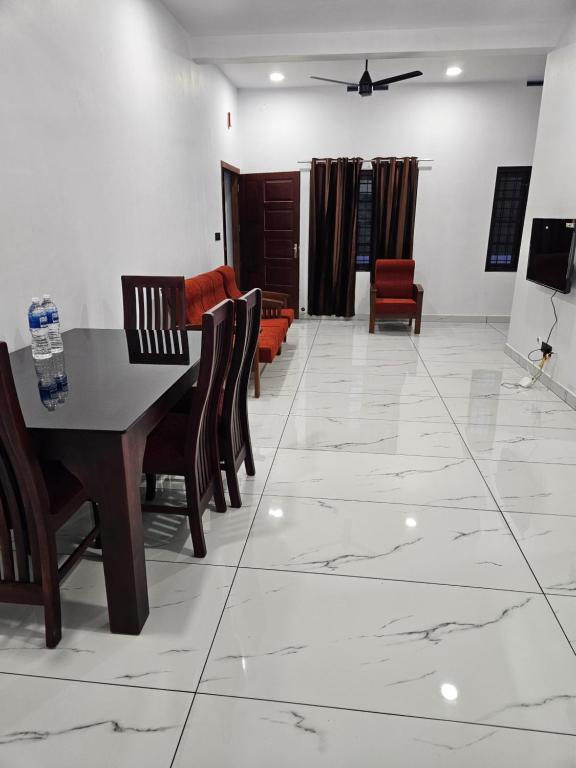 sala de estar con mesa y sillas en MATHER RAJAGIRI FURNISHED APARTMENTS, en Alwaye