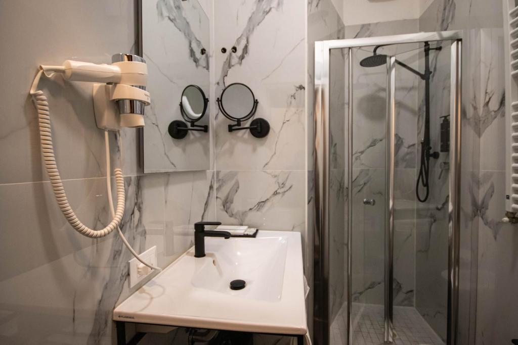 ein Bad mit einem Waschbecken und einer Dusche in der Unterkunft Emma Hotel Bologna Fiera in Bologna