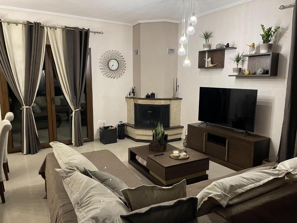 uma sala de estar com um sofá e uma televisão de ecrã plano em Luxury Sweet Home em Agria