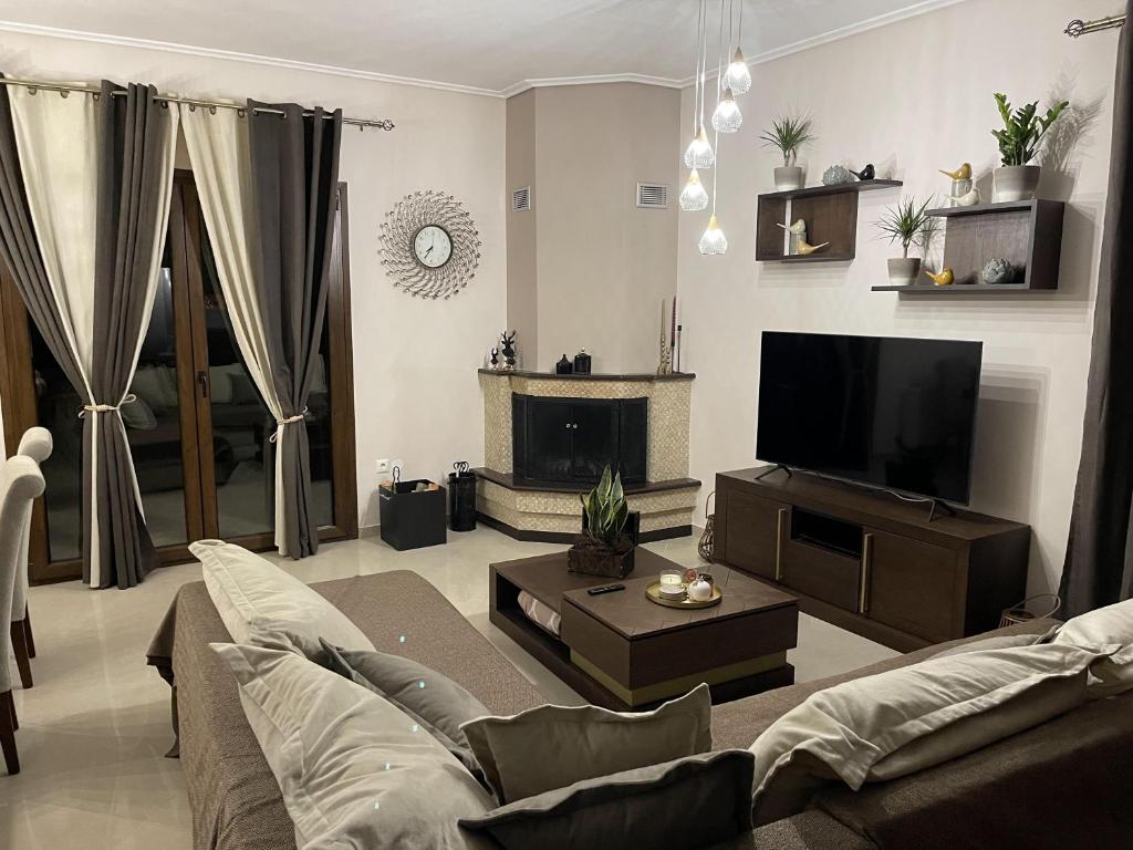 salon z kanapą i telewizorem z płaskim ekranem w obiekcie Luxury Sweet Home w mieście Agria