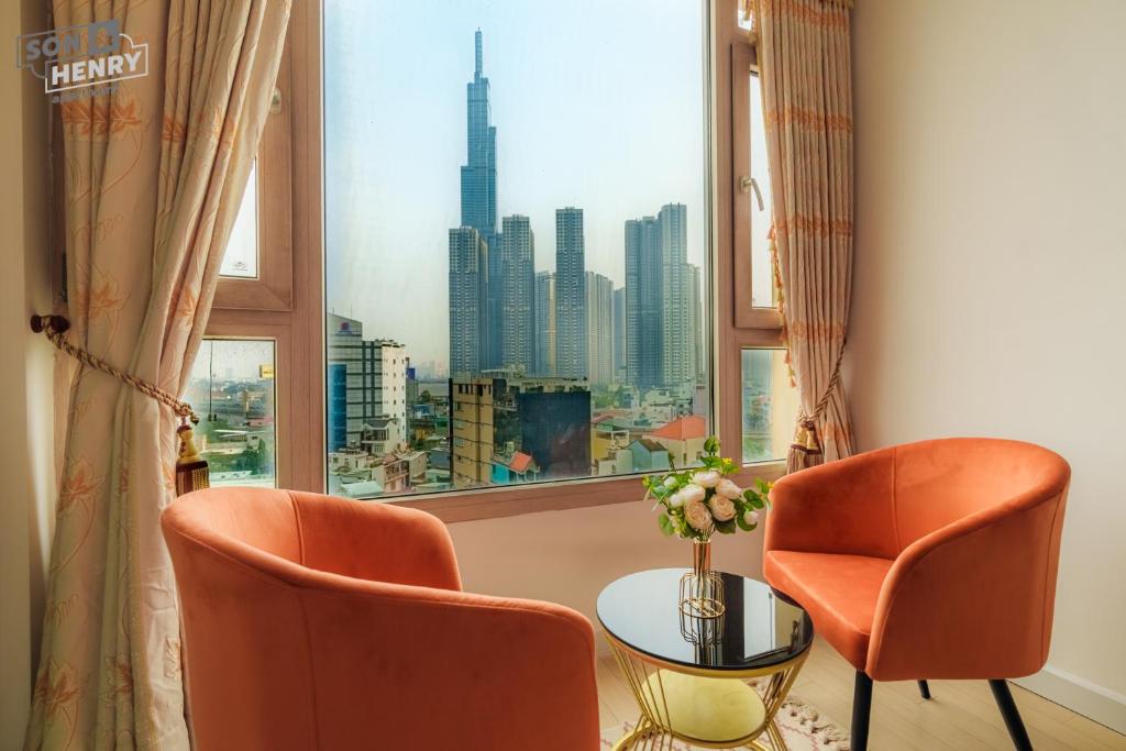 ein Zimmer mit zwei Stühlen und einem Tisch und einem Fenster in der Unterkunft Son&Henry Cantavil Korean Apt in Ho-Chi-Minh-Stadt