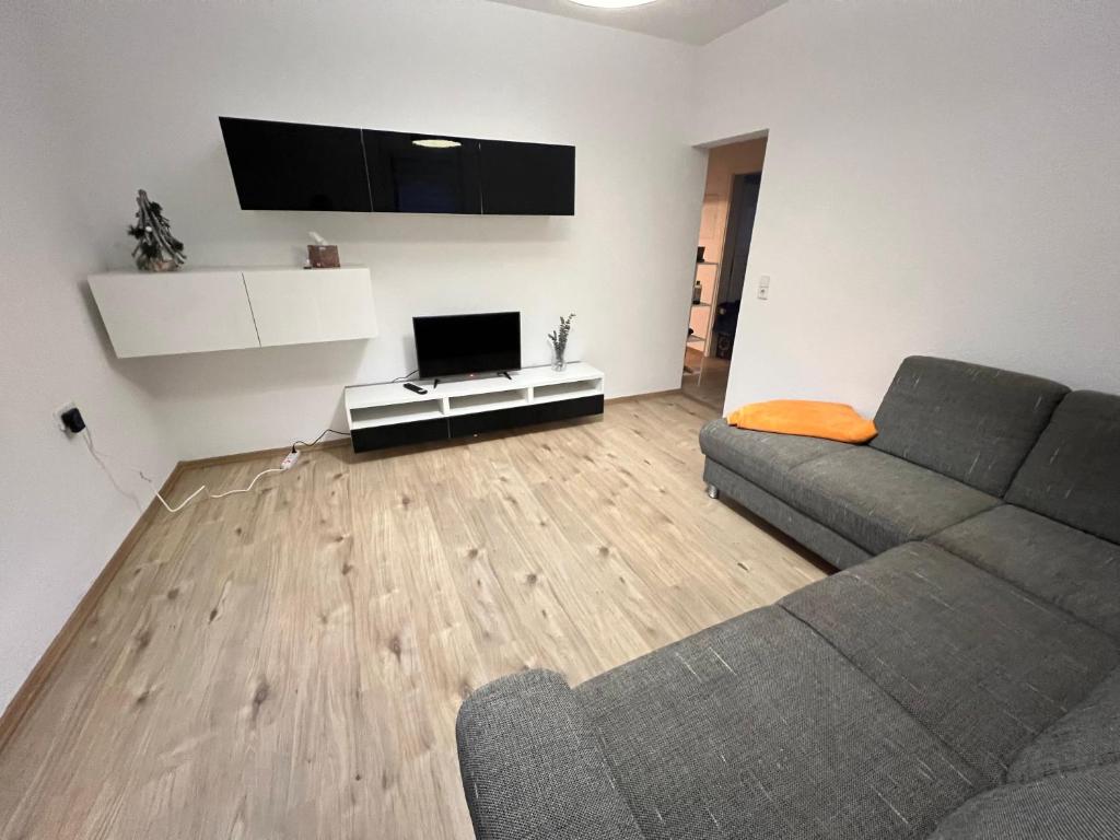 ein Wohnzimmer mit einem Sofa und einem Flachbild-TV in der Unterkunft Gemütliche 2 Z. Wohnung mit Charme in Trossingen