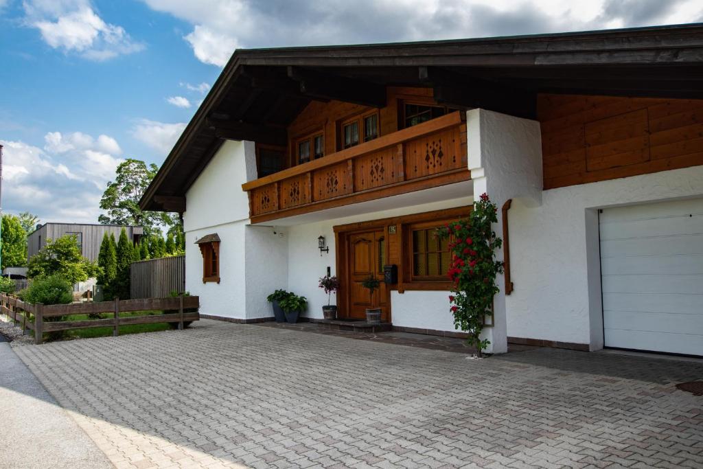 a white house with a wooden door and a driveway at Auers Ferienwohnung ITD099 in Itter
