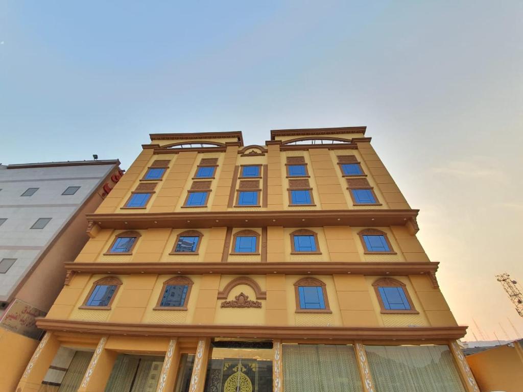 فندق انوار المشاعرالفندقية في مكة المكرمة: مبنى أصفر طويل مع نوافذ زرقاء