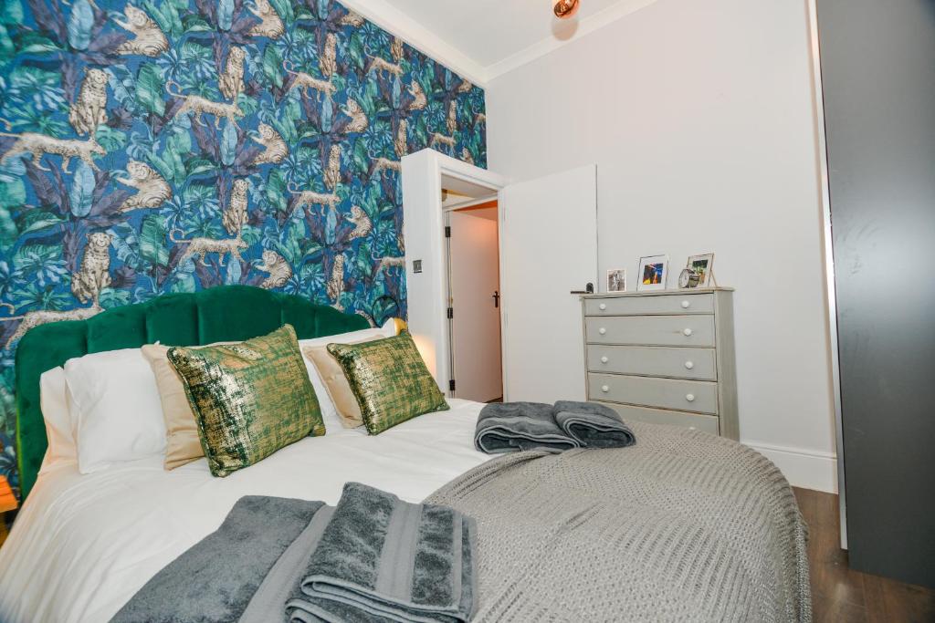 a bedroom with a bed with a green headboard at Cosy 1 bedroom home for small families in London