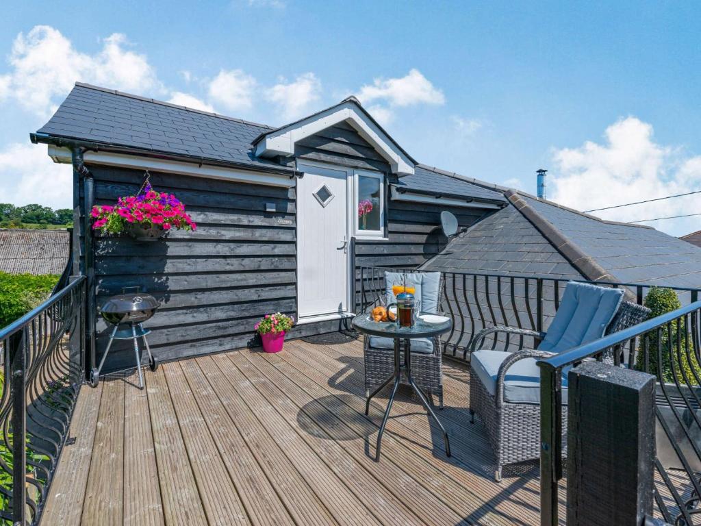 a deck with a cabin with a table and chairs at 1 Bed in Fairlight 88470 in Fairlight