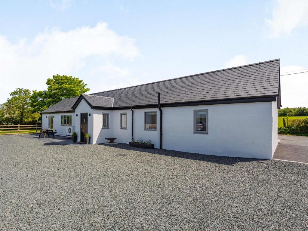 a white building with a gravel driveway in front of it at 2 bed in Caernarfon 88043 in Caernarfon