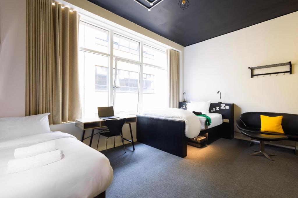 Pokój hotelowy z 2 łóżkami, biurkiem i oknem w obiekcie REZz Dublin w Dublinie