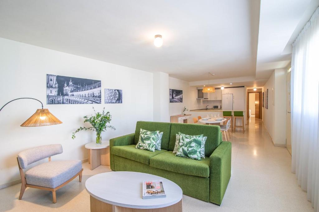 ein Wohnzimmer mit einem grünen Sofa und einem Tisch in der Unterkunft Pierre & Vacances Sevilla in Sevilla