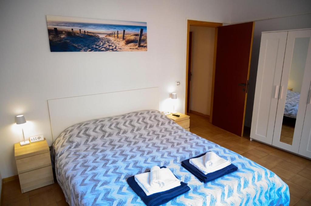 een slaapkamer met een bed met twee handdoeken erop bij Appartamento Cialdini Centro Ancona in Ancona