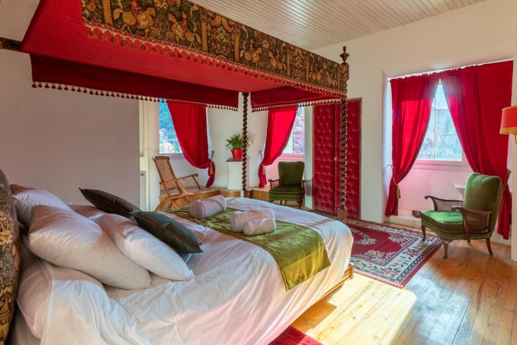 1 dormitorio con 1 cama grande y cortinas rojas en Château le Beylon - Chambres d'hôtes en Montmaur