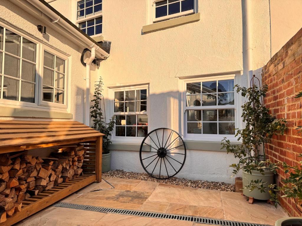 a patio with a wheel next to a building at Pilchard Cottage in Dawlish