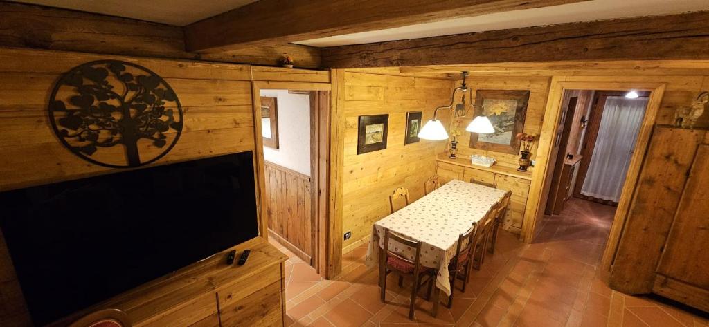 ein Zimmer mit einem Tisch in einem Holzhaus in der Unterkunft COURMAYEUR, VERRAND: IMMERSA NEL VERDE E CON VISTA in Verrand