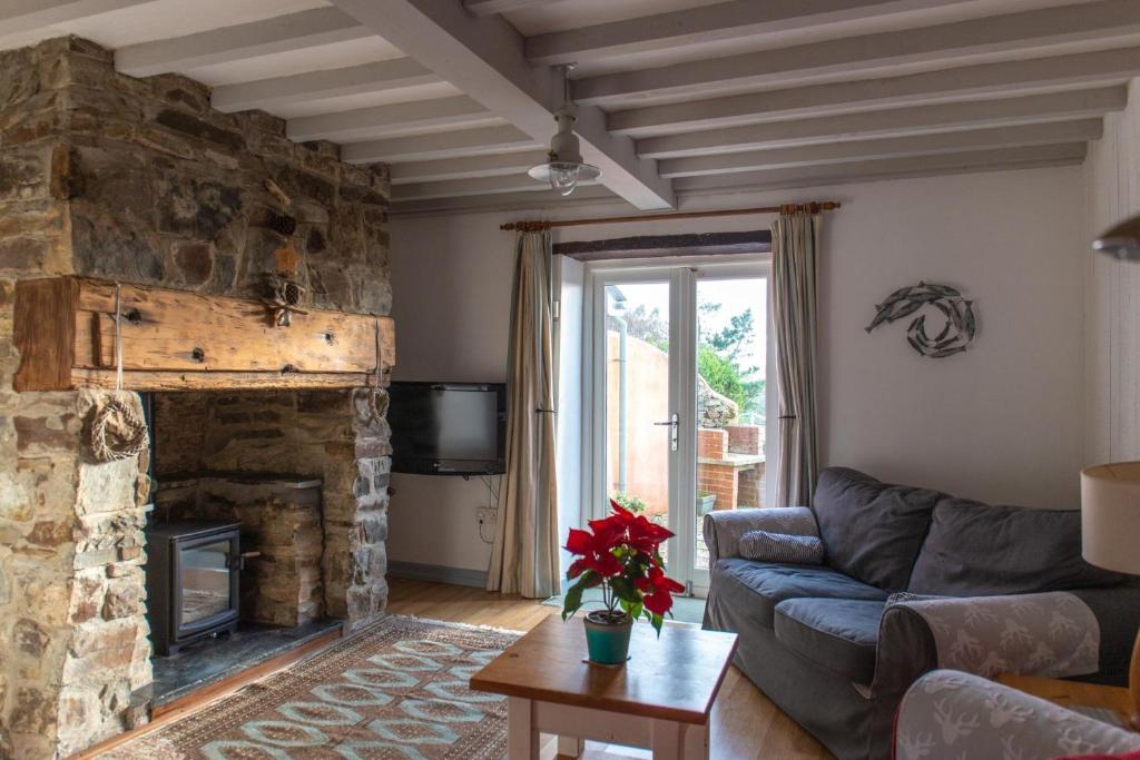 a living room with a couch and a stone fireplace at The Granary in Hartland