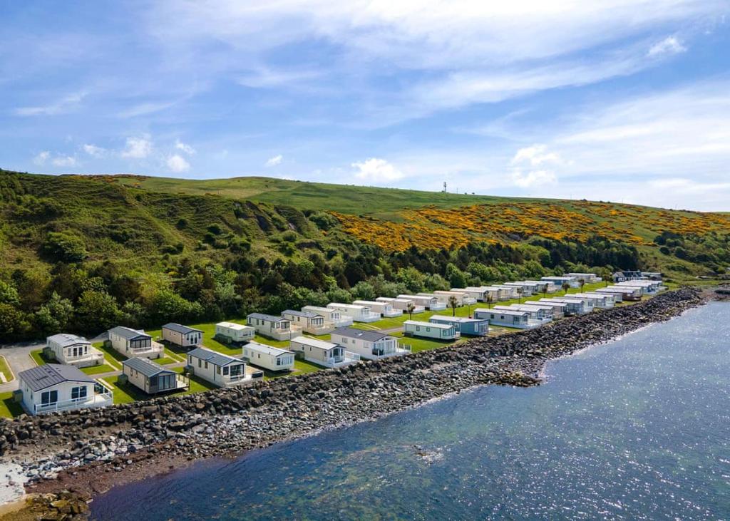 an aerial view of a row of houses next to the water at Bennane Shore Holiday Park in Lendalfoot