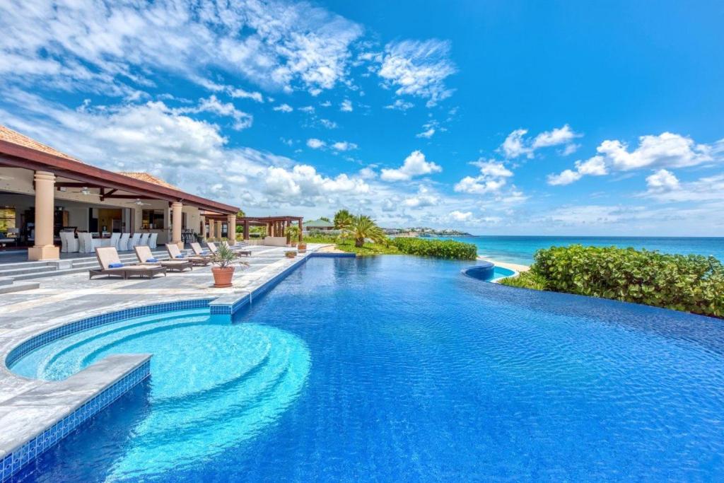 a swimming pool with a view of the ocean at Casa la Playa in Baie Longue