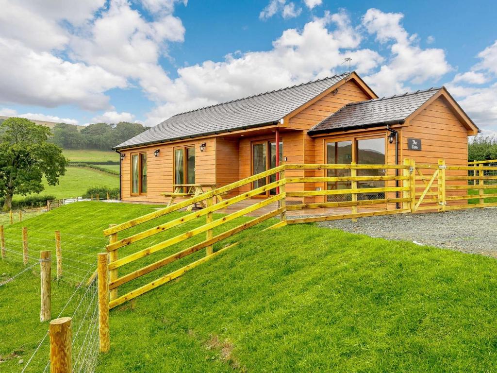 ein Holzhaus mit einem Zaun davor in der Unterkunft 2 bed in Llandrindod Wells 89063 in Nantmel