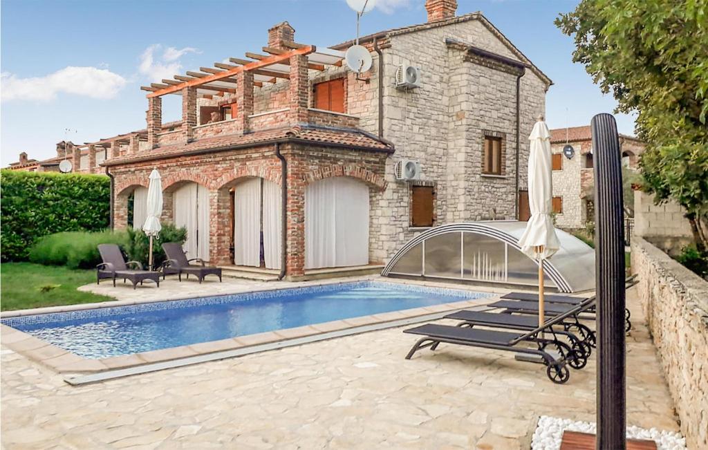 Villa con piscina frente a una casa en Gorgeous Home In Cabrunici With Outdoor Swimming Pool, en Čabrunići
