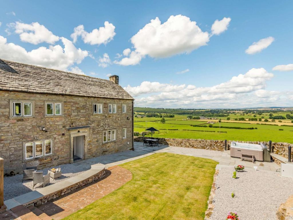 an external view of a stone house with a patio at 3 Bed in Pooley Bridge 89068 in Tirril