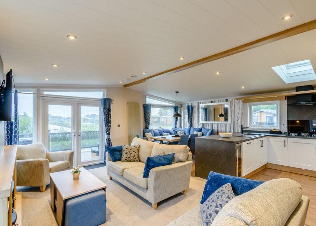 a living room with couches and a kitchen at Hanworth Country Park in Potter Hanworth