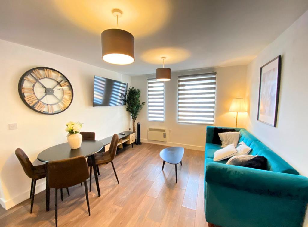 a living room with a blue couch and a table at Manchester Apartments by BEVOLVE - City Centre in Manchester