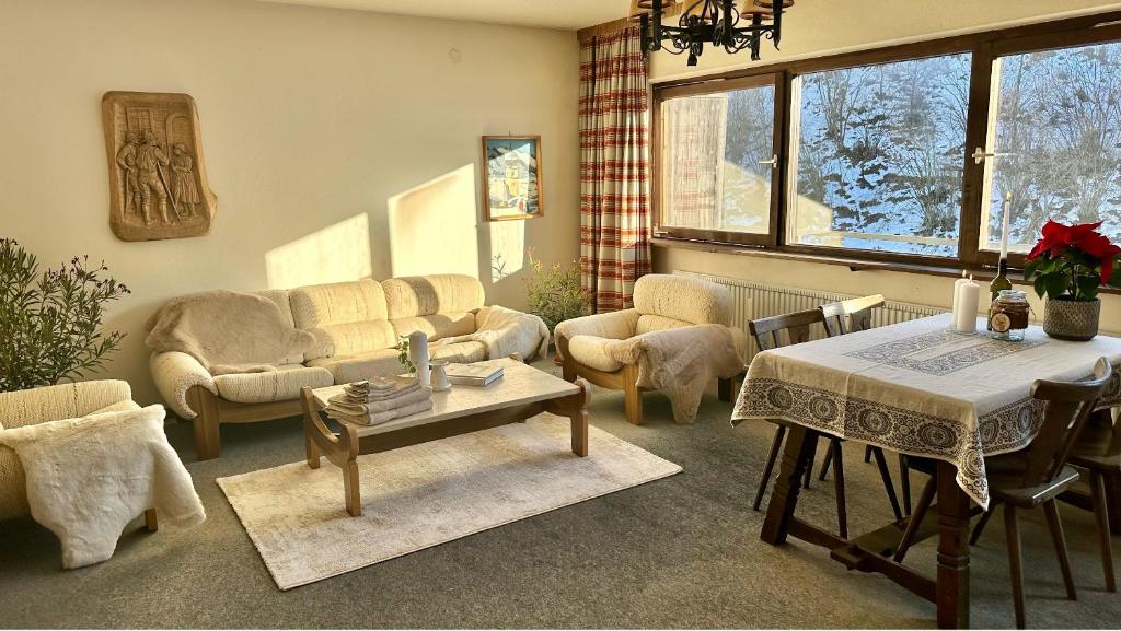 - un salon avec des canapés, une table et des chaises dans l'établissement Apartment A'Horn, à St. Johann in Tirol