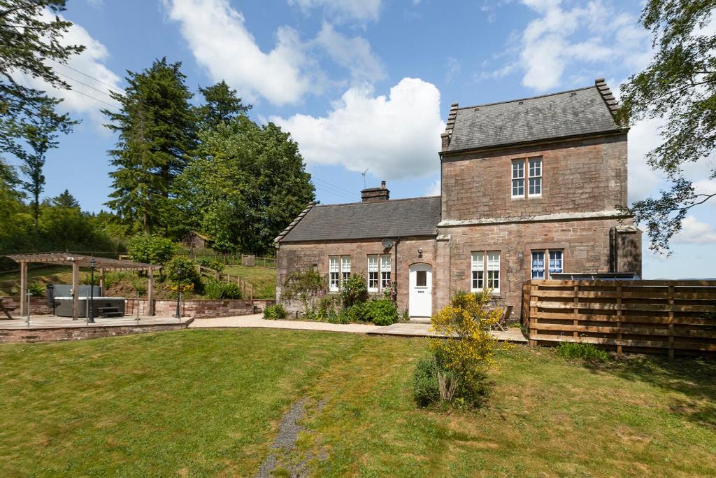 an old brick house with a yard in front of it at Laundry Cottage: Drumlanrig Castle in Thornhill