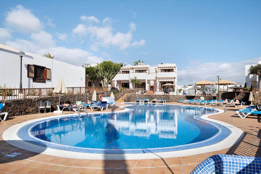 a large swimming pool with blue water in a resort at Playa Flamingo 19 in Playa Blanca