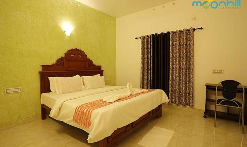 een slaapkamer met een groot bed in een kamer bij FabHotel Prime Moon Hill Resorts in Munnar