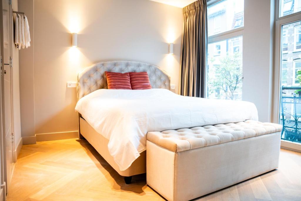 a bedroom with a bed and a large window at Renovated Parkside Gem - 2 person studio in the Pijp in Amsterdam