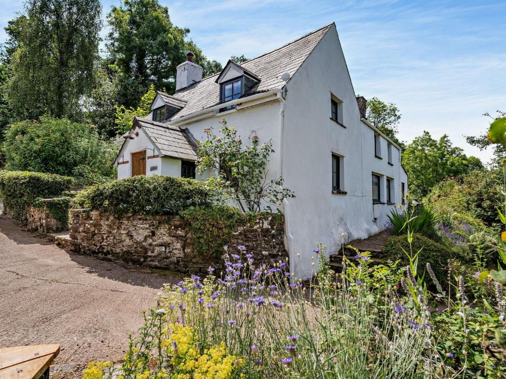 a white house with flowers in front of it at 3 Bed in Brecon 56811 in Llangynidr