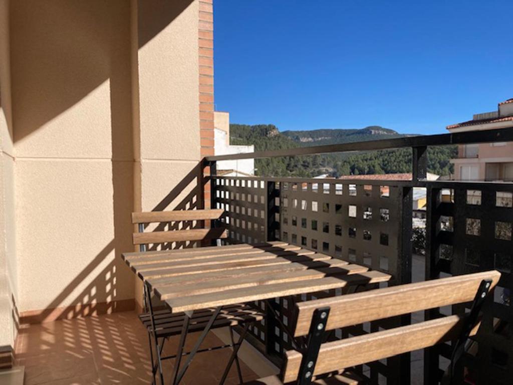 uma mesa de madeira e dois bancos numa varanda em Apartamento en Montanejos em Montanejos