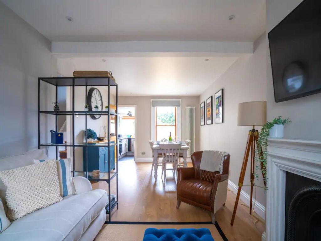 ein Wohnzimmer mit einer weißen Couch und einem Kamin in der Unterkunft Central Victorian terraced house Patio Garden - Pass the Keys in Cheltenham