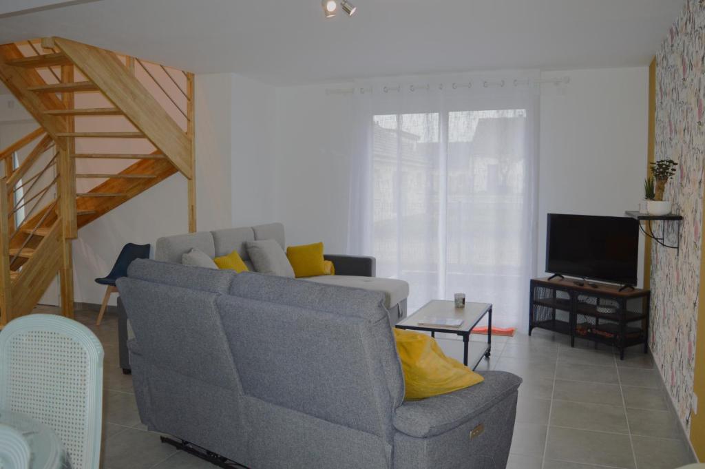 - un salon avec un canapé et une télévision dans l'établissement Les embruns, maison neuve près des plages, à Asnelles