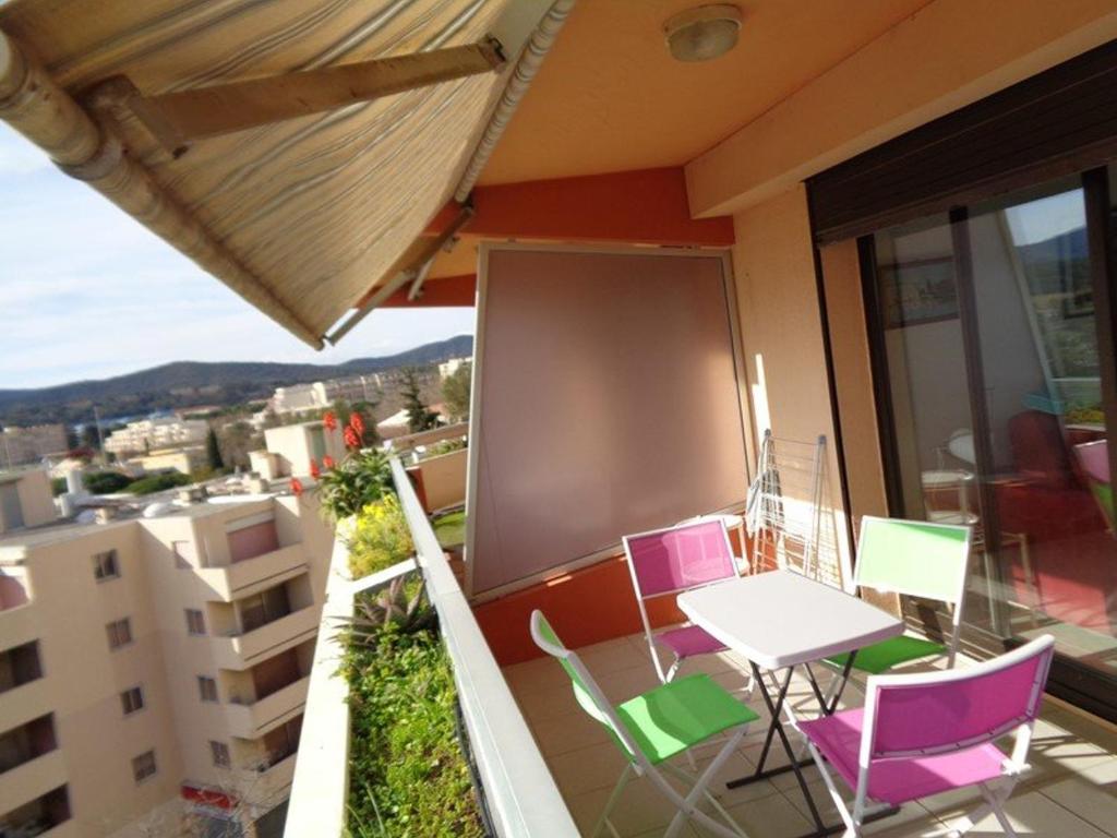 een balkon met een tafel en stoelen en een projectiescherm bij Studio Le Lavandou, 1 pièce, 2 personnes - FR-1-308-73 in Le Lavandou