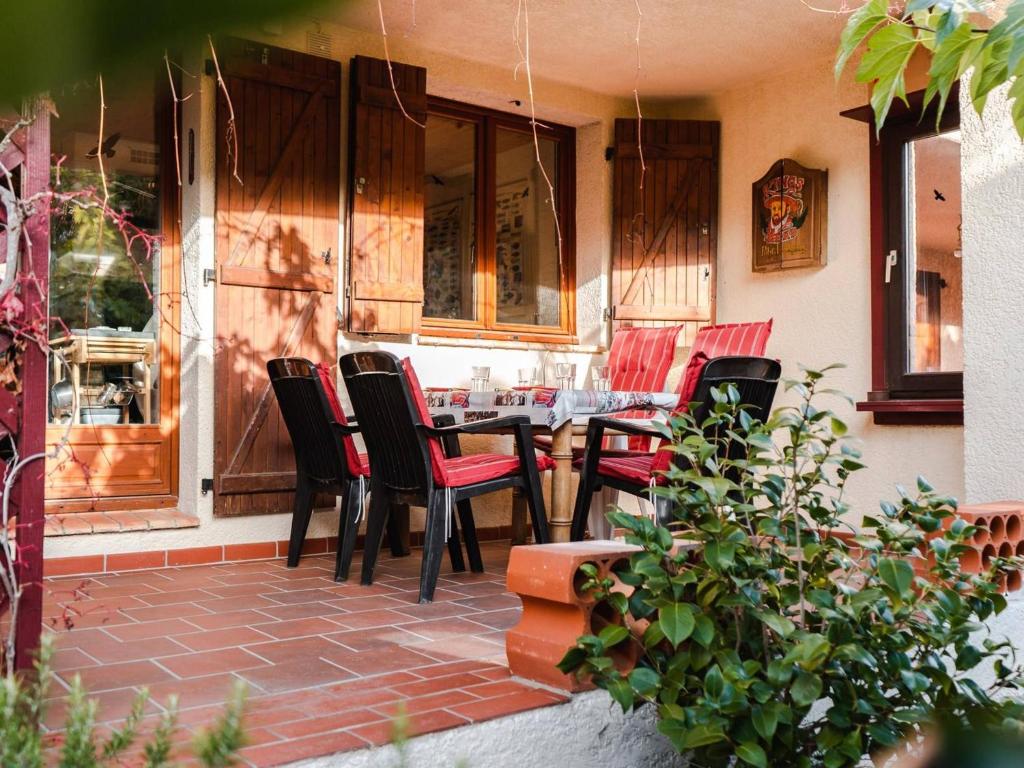 un patio avec des chaises et une table devant un bâtiment dans l'établissement Villa 4 pièces avec jardin, terrasse, animaux permis, parking - FR-1-409-26, à Saint Pierre La Mer