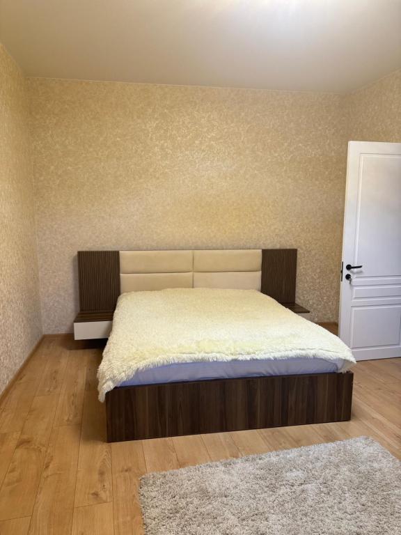 Un dormitorio con una cama grande con una colcha blanca. en TbilApartments, en Tiflis