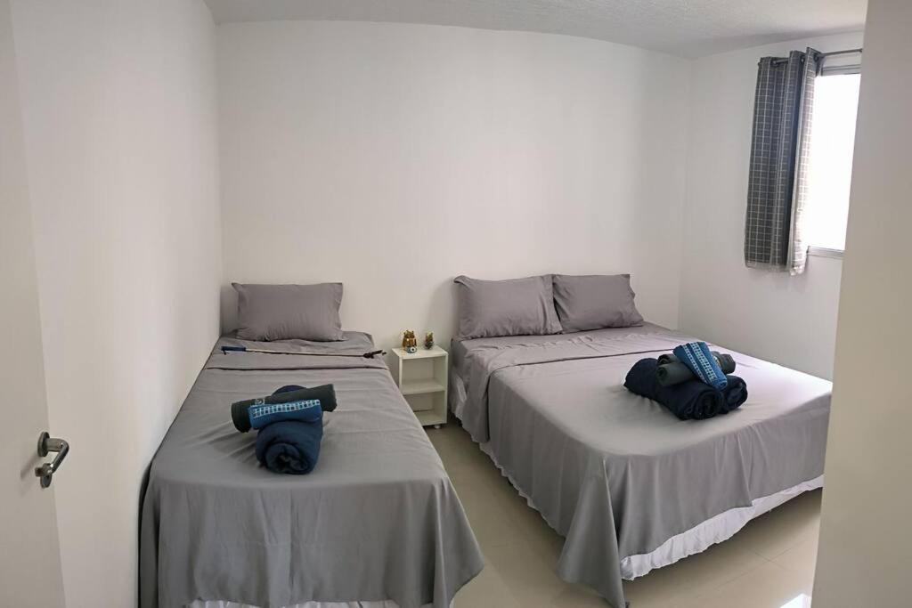2 Betten nebeneinander in einem Zimmer in der Unterkunft *Apê 104- perto Dutra, Graal e Aman. in Resende