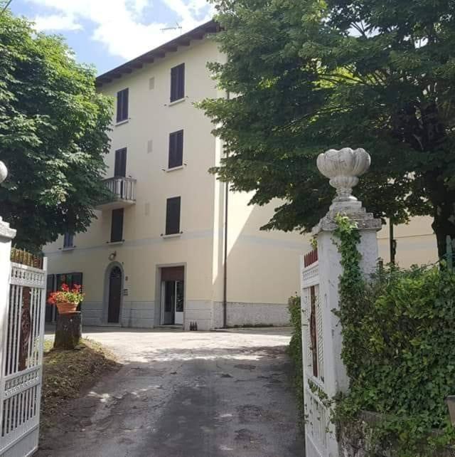 une clôture blanche devant un bâtiment dans l'établissement residence La Bolognina 2, à Lizzano in Belvedere