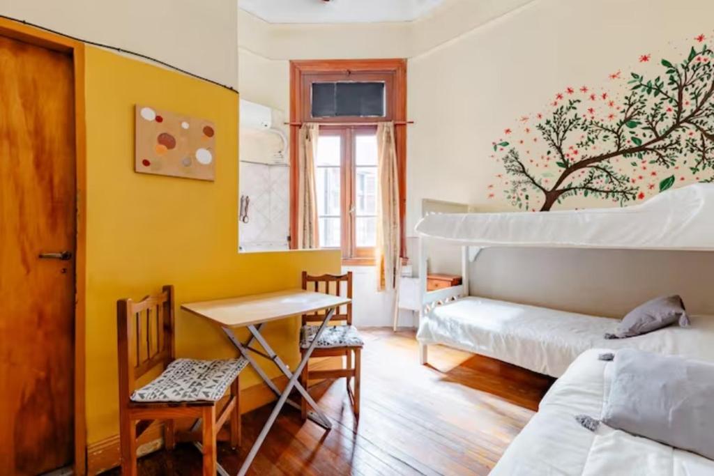 1 dormitorio con cama, escritorio y mesa en Dante y compañia en Buenos Aires