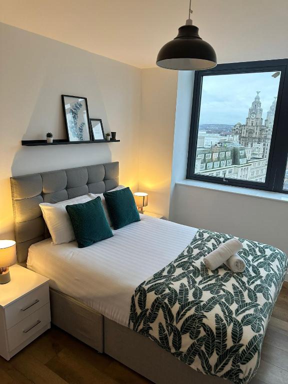 a bedroom with a bed with a large window at Stunning City View Apartment by Central Stay in Liverpool