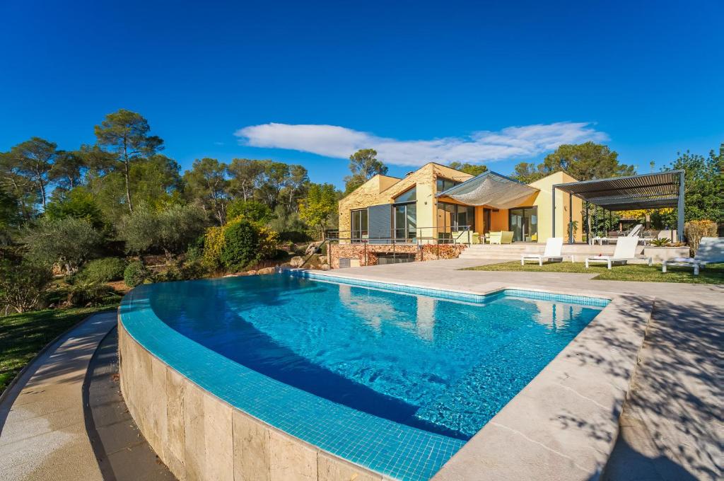 a swimming pool in front of a house at Villa Laiar in Sencelles