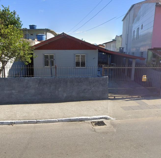 una calle con una valla y una casa en Casa Cachoeira do bom Jesus, en Florianópolis