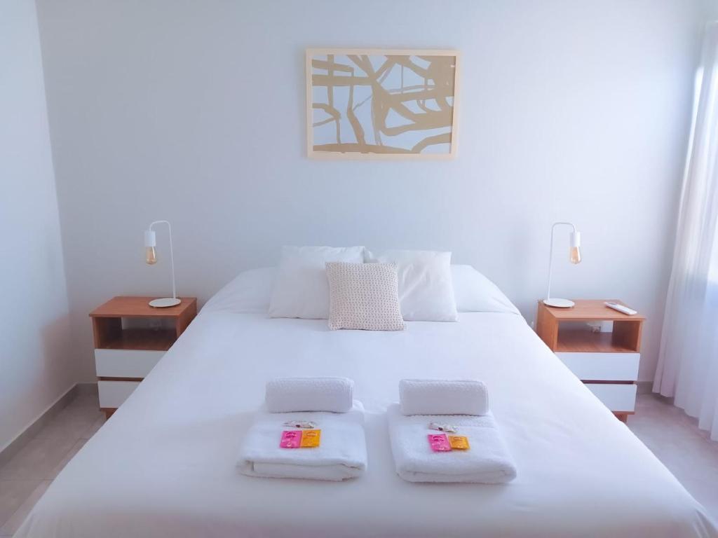 una camera con un letto bianco con due comodini di Pueyrredon 440 a Santa Rosa