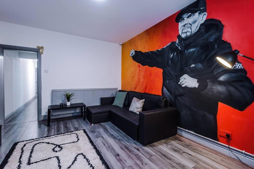 a living room with a large painting on the wall at LFC Themed Apartment in Liverpool