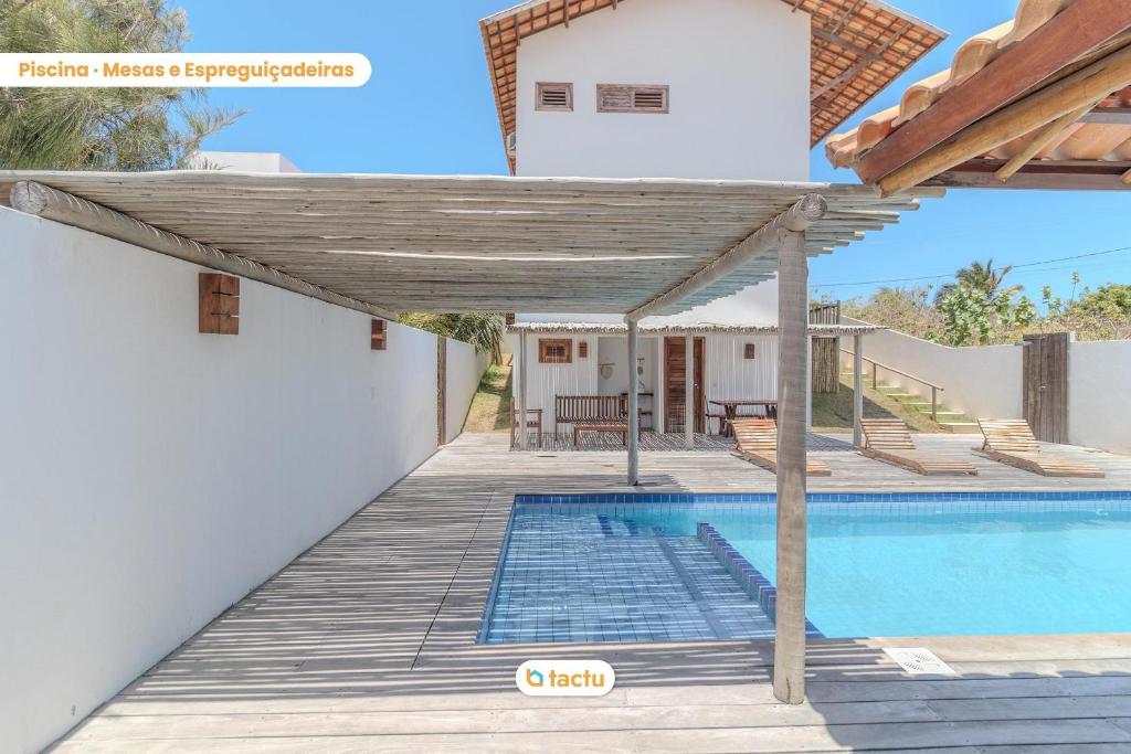 a villa with a swimming pool and a pergola at Apto 100m da praia no Pontal de Maceió por Tactu in Maceio
