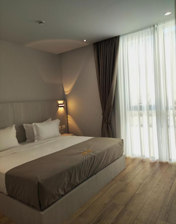a bedroom with a bed and a large window at Metro Hotel Terminal in Tirana