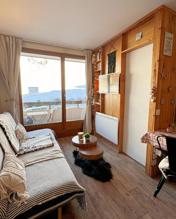 une chambre avec un lit, une table et une fenêtre dans l'établissement Le Cocon des Cimes 2 à 5 pers., à La Plagne Tarentaise